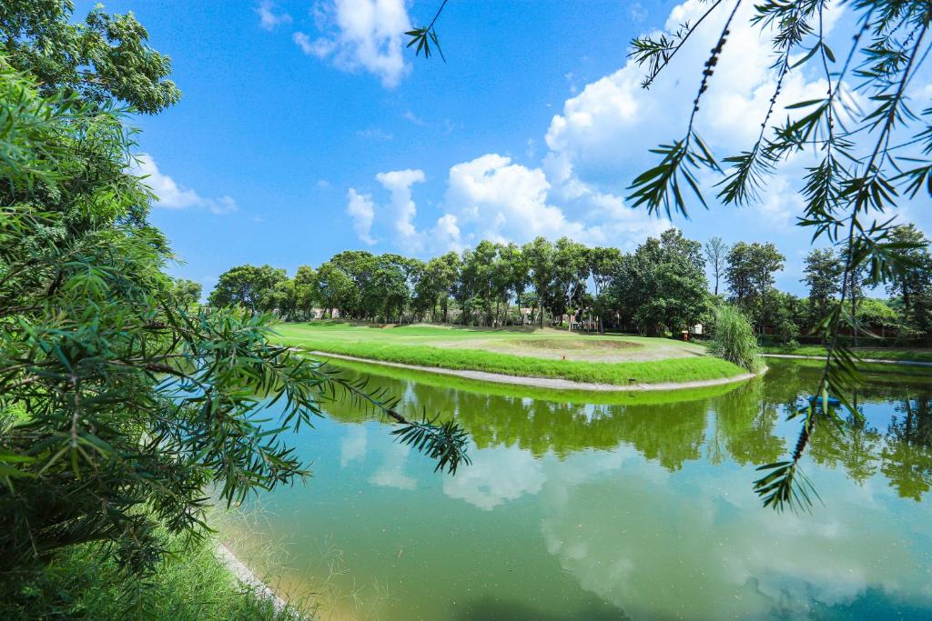 Mukteshwar Nature Trail Experience: A Peaceful Escape into Nature Experience A Peaceful Escape into Nature with a serene lake, lush greenery, and beautiful reflections under a bright blue sky